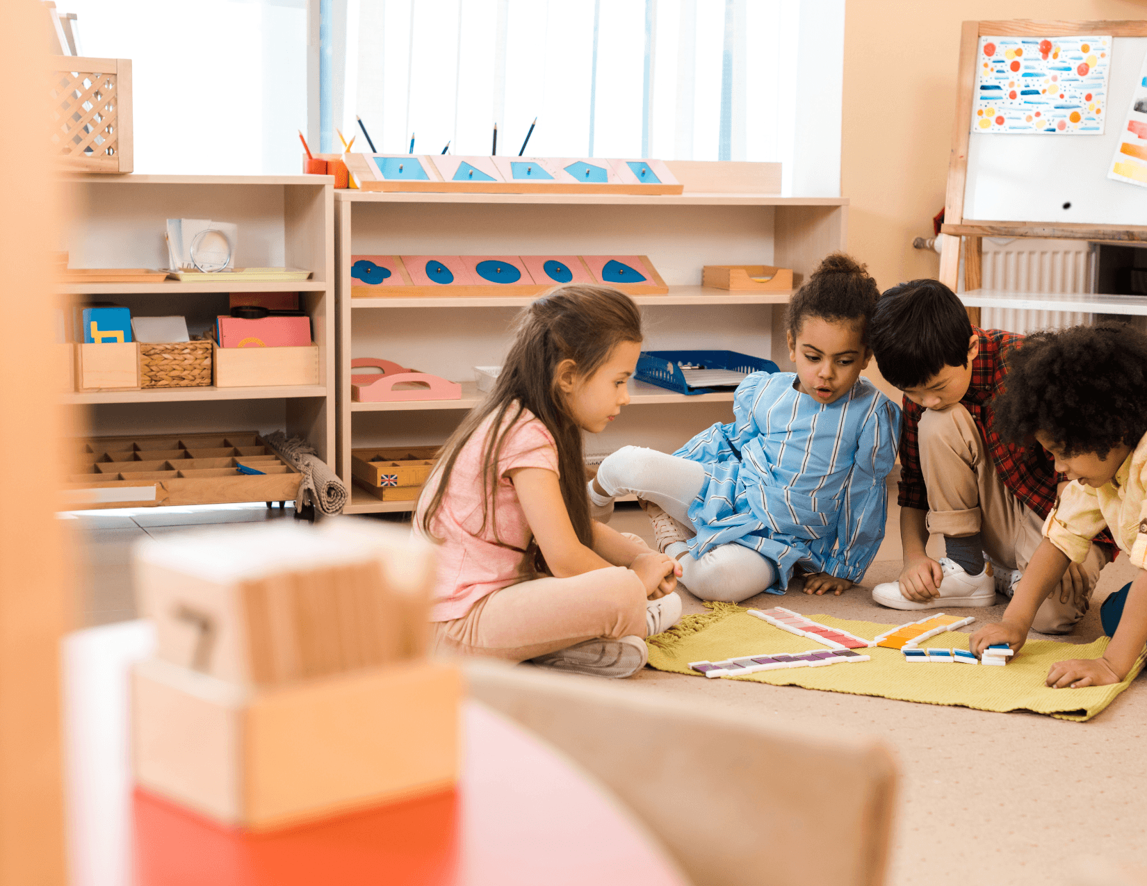 Montessori guide working with children on the floor